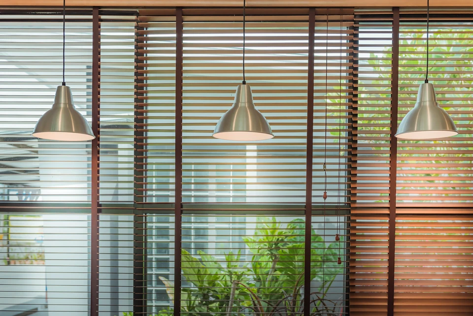 Intérieur moderne avec grandes baies vitrées équipées de stores vénitiens en bois