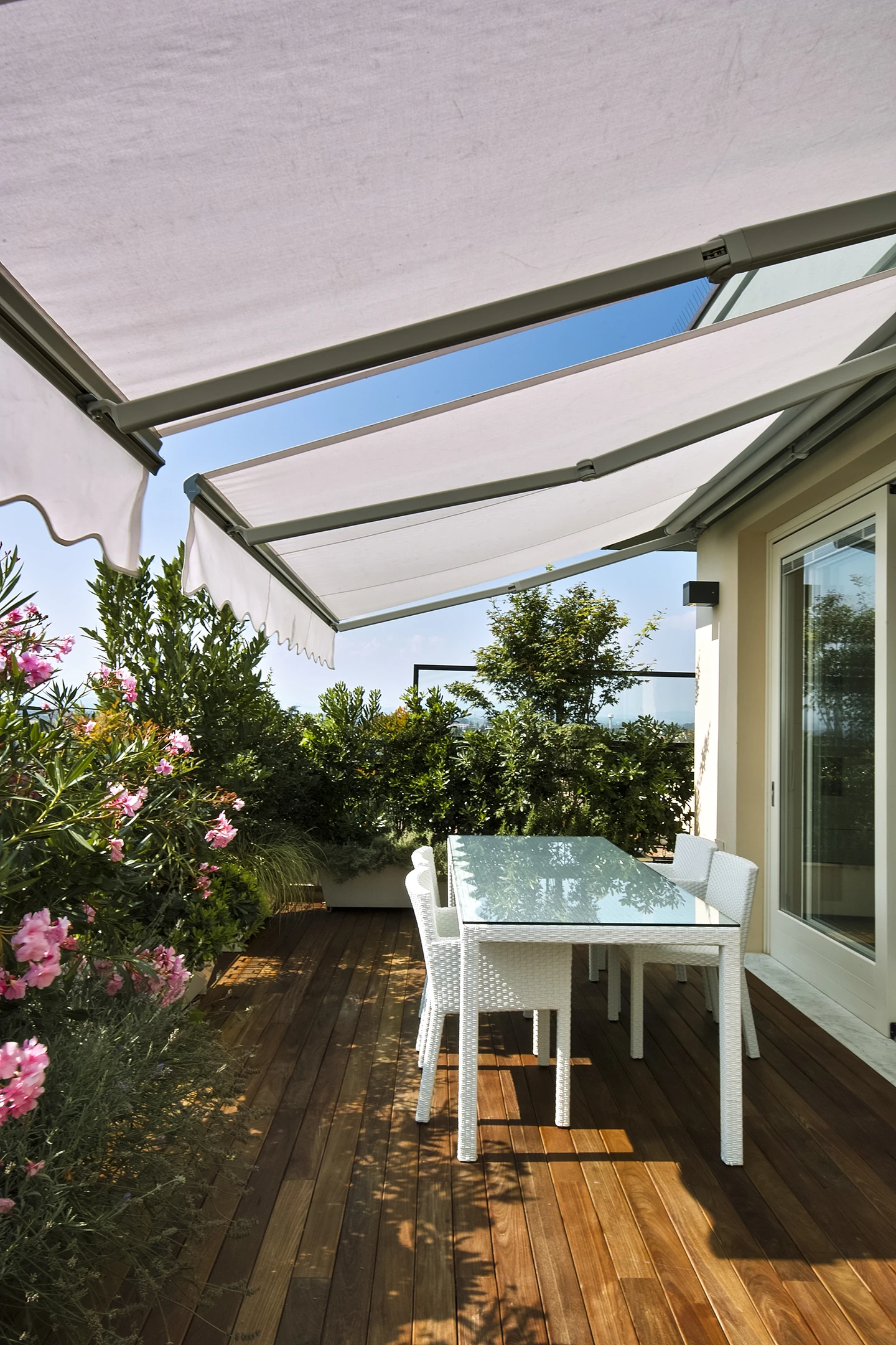 Terrasse extérieure avec pergola bioclimatique à lames orientables et toile d'ombrage rétractable blanche