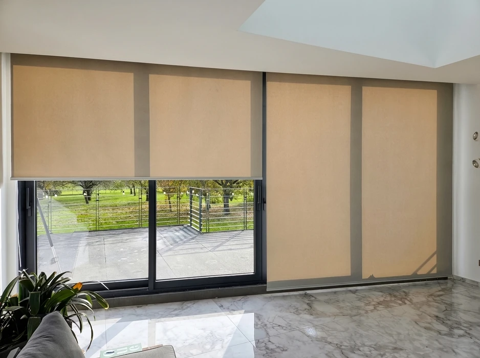Intérieur moderne lumineux avec grandes baies vitrées coulissantes équipées de stores enrouleurs semi-opaques couleur sable/beige
