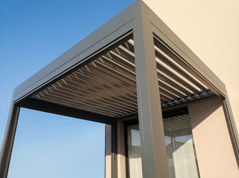 Pergola bioclimatique aluminium anthracite, fixée en about de façade, toiture à lames orientables en position ouverte