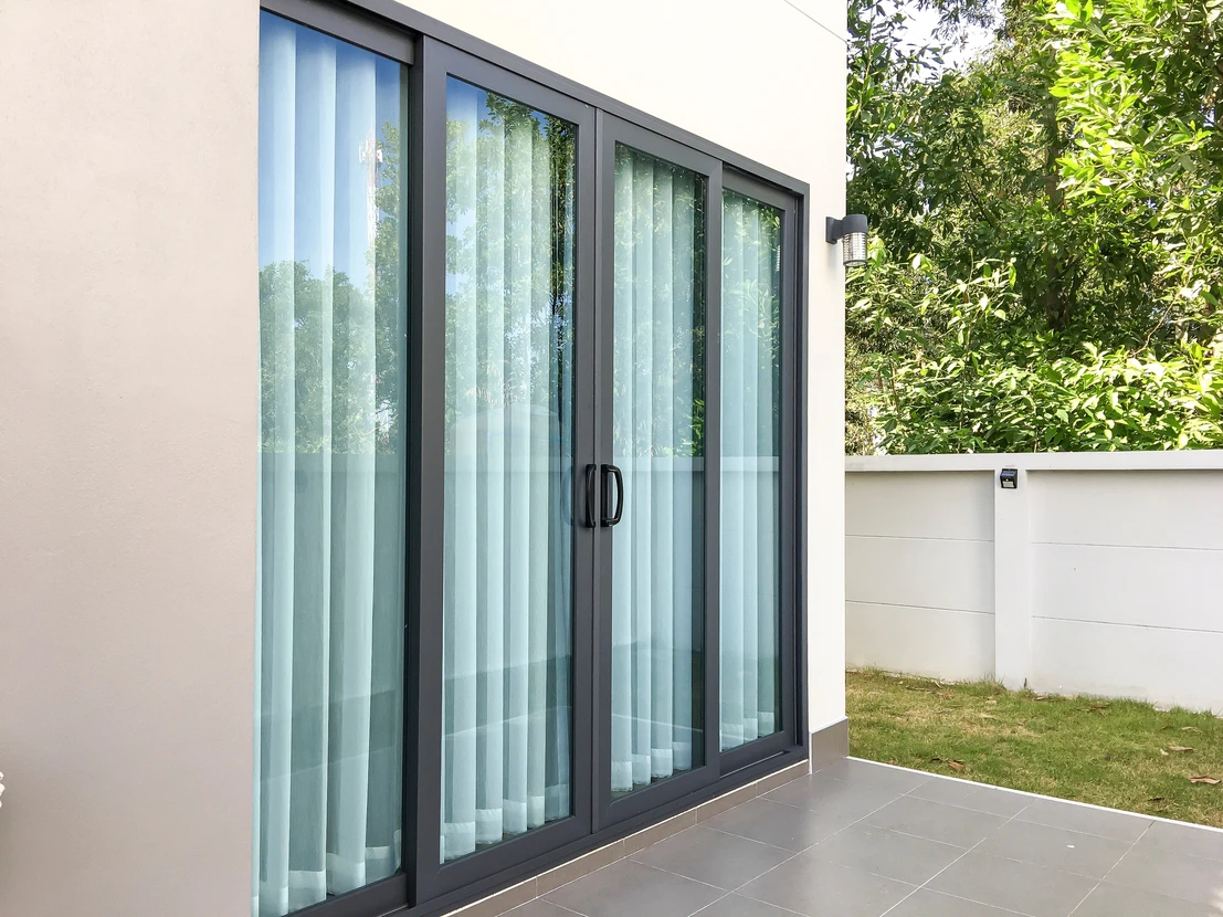 Extérieur résidentiel moderne avec pergola bioclimatique à lames orientables installée devant une maison contemporaine blanche