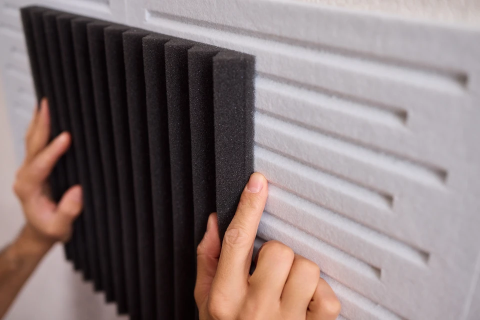 Technicien en gilet de sécurité haute visibilité effectuant des mesures acoustiques sur chantier extérieur avec sonomètre professionnel