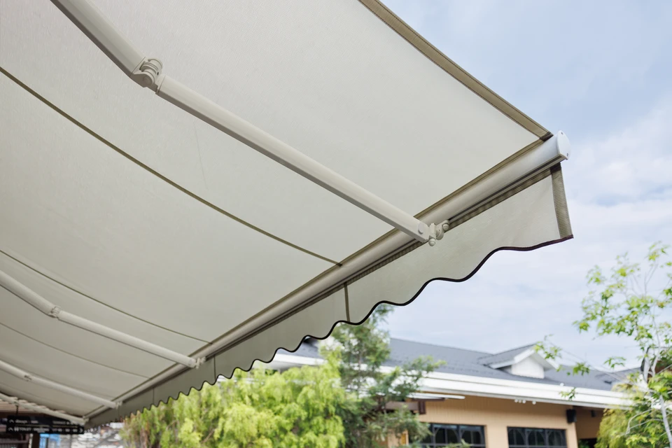 Terrasse extérieure avec store banne déployé sous ciel bleu