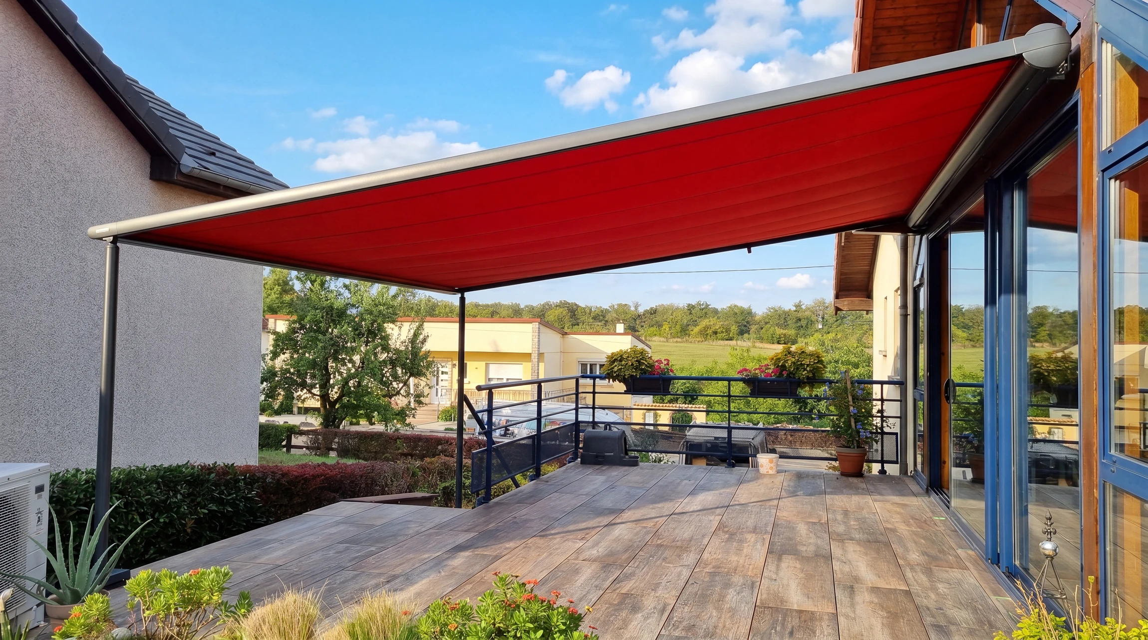 Scène extérieure montrant une pergola bioclimatique moderne adossée à une habitation