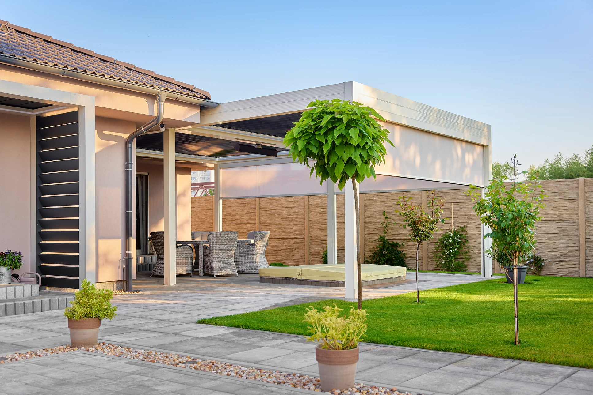 Extérieur résidentiel moderne avec pergola bioclimatique à lames orientables installée devant une maison contemporaine blanche