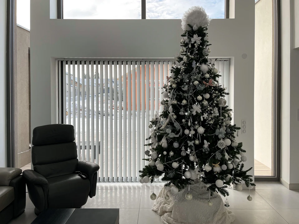 Intérieur moderne lumineux avec grandes baies vitrées coulissantes équipées de stores enrouleurs semi-opaques couleur sable/beige